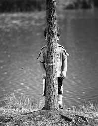 kid behind tree